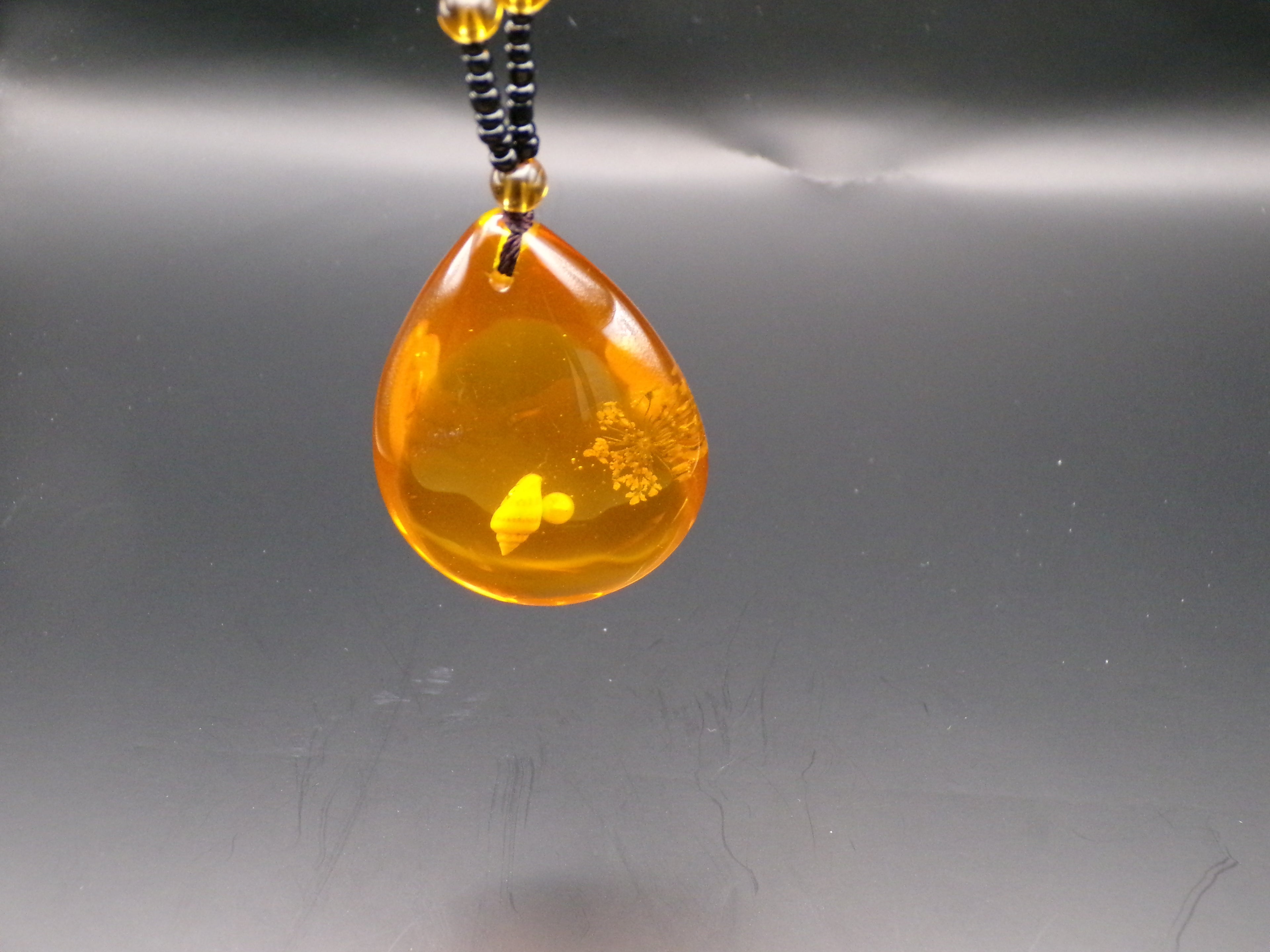 Κολιέ με χάντρες σε κεχριμπαρένια απόχρωση και μενταγιόν σε σχήμα δάκρυ